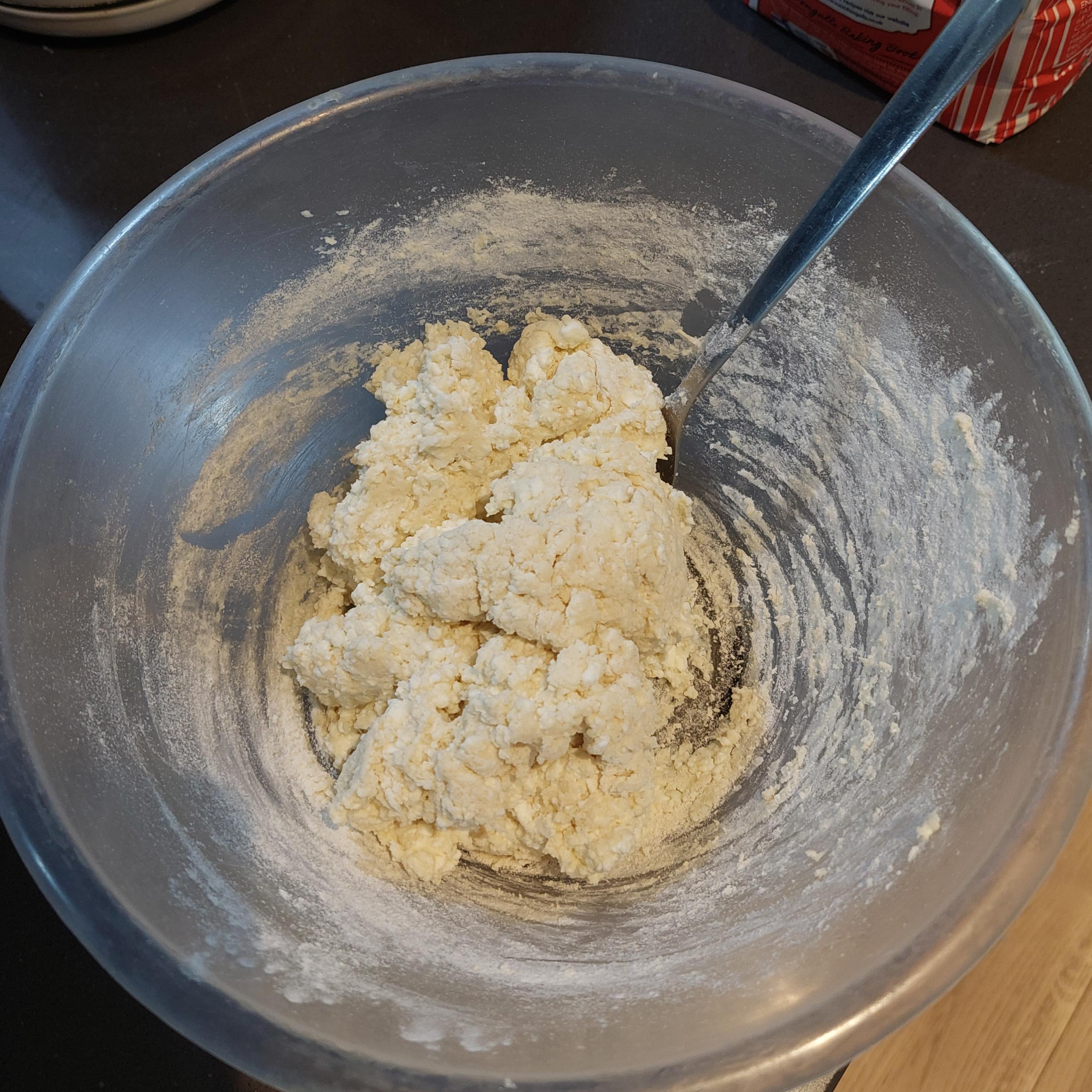 Keep adding flour and mixing it into mixture until it's no longer wet and starts to stick together.