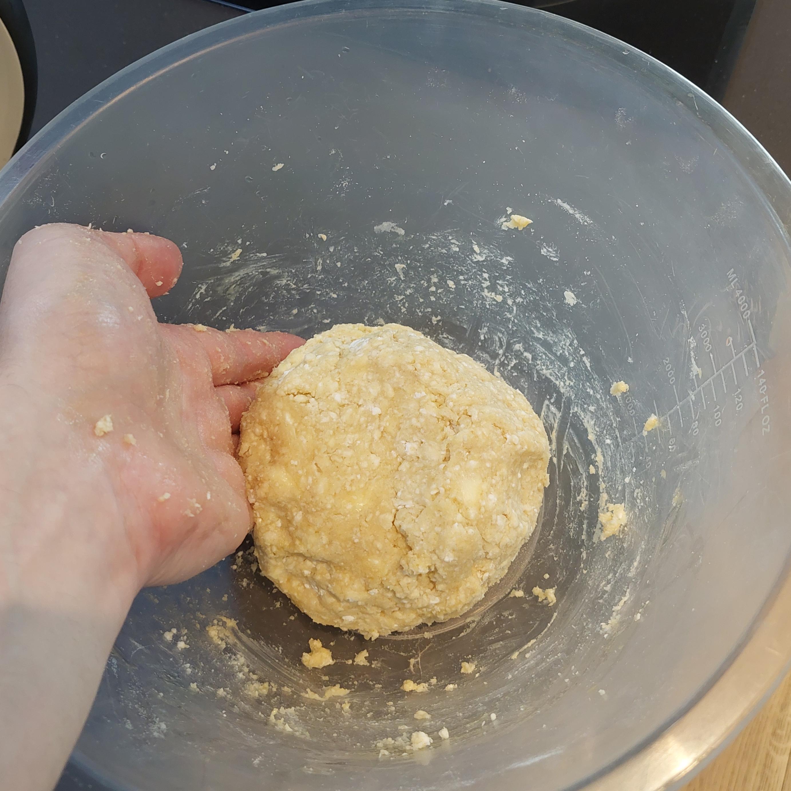 Add egg yolk and work the mixture with hands into a ball of dough. Save egg whites for a later step.